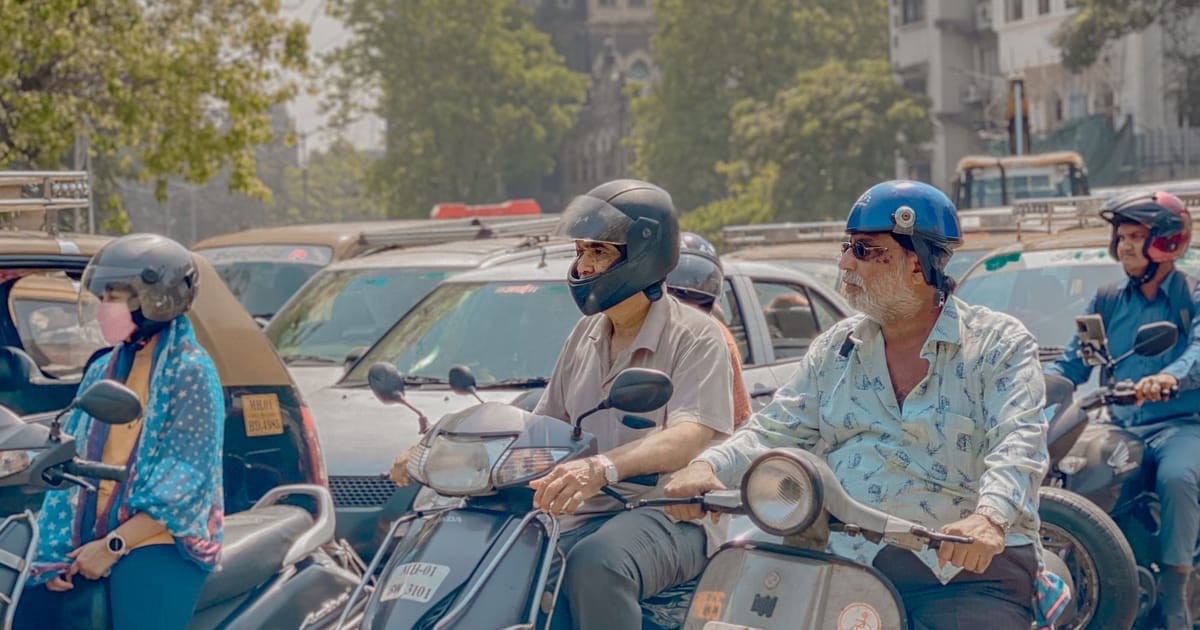 A busy Indian street with scooters and motorcycles in traffic.