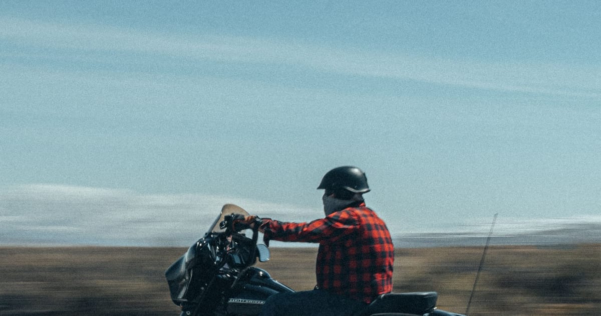 A rider on an open road under a clear sky.